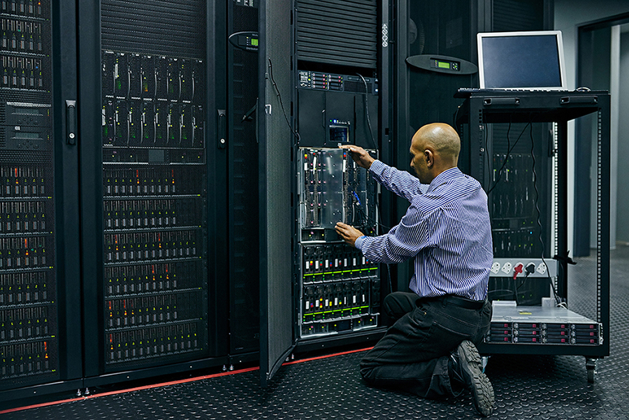 Engineer in a server room working on mainframe equipment